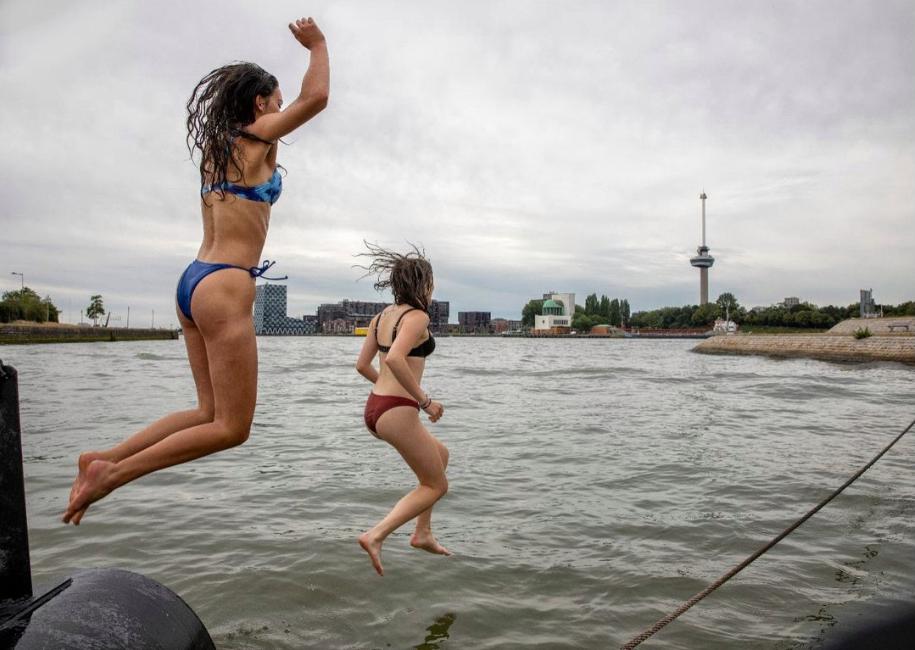 2 meisjes die in het water springen met uitzicht op de Euromast In  Rotterdam