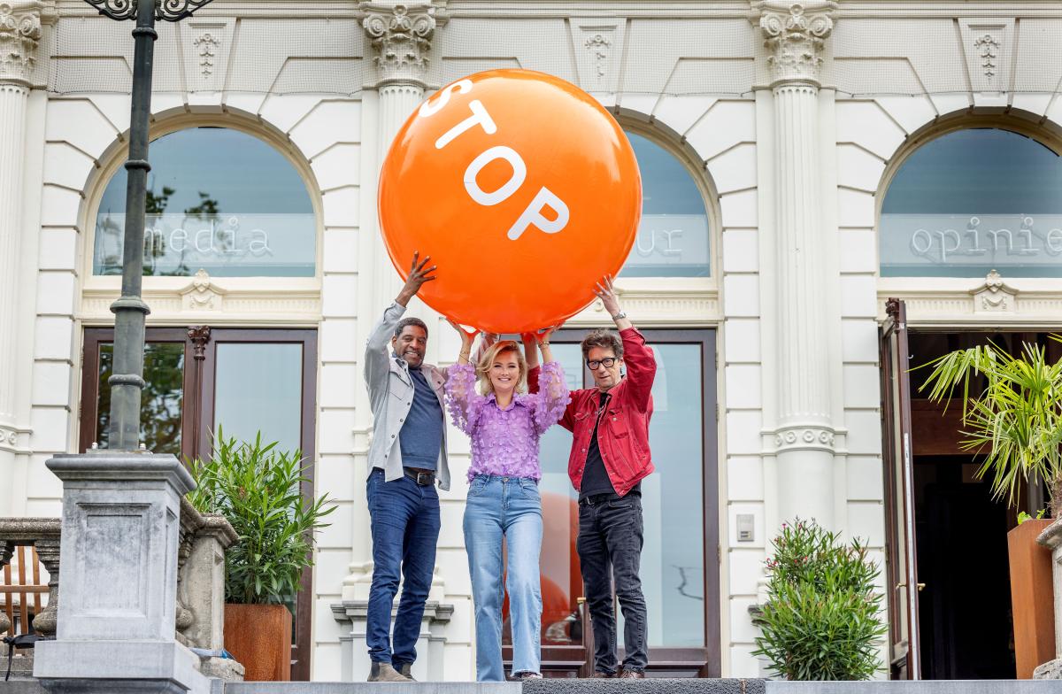 Drie bekende Nederlanders houden de oranje stoptober bal omhoog