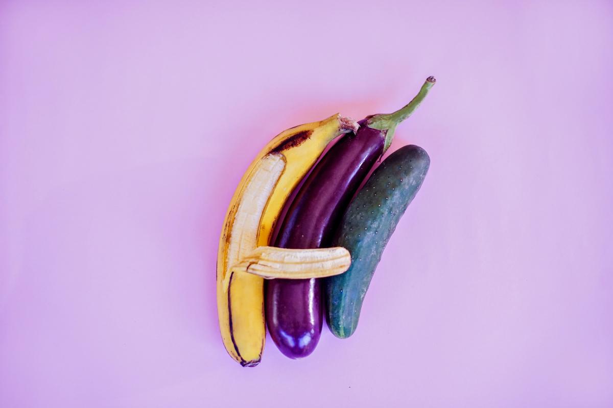 Een banaan, aubergine en komkommer die knuffelen